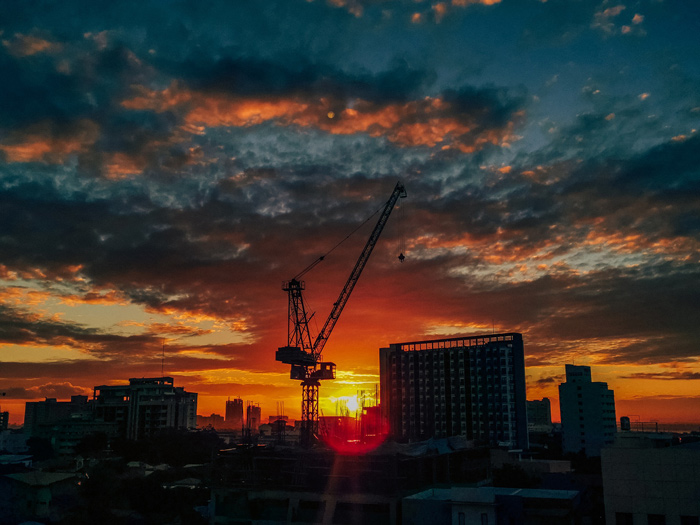 Construction crane backlit by sunset